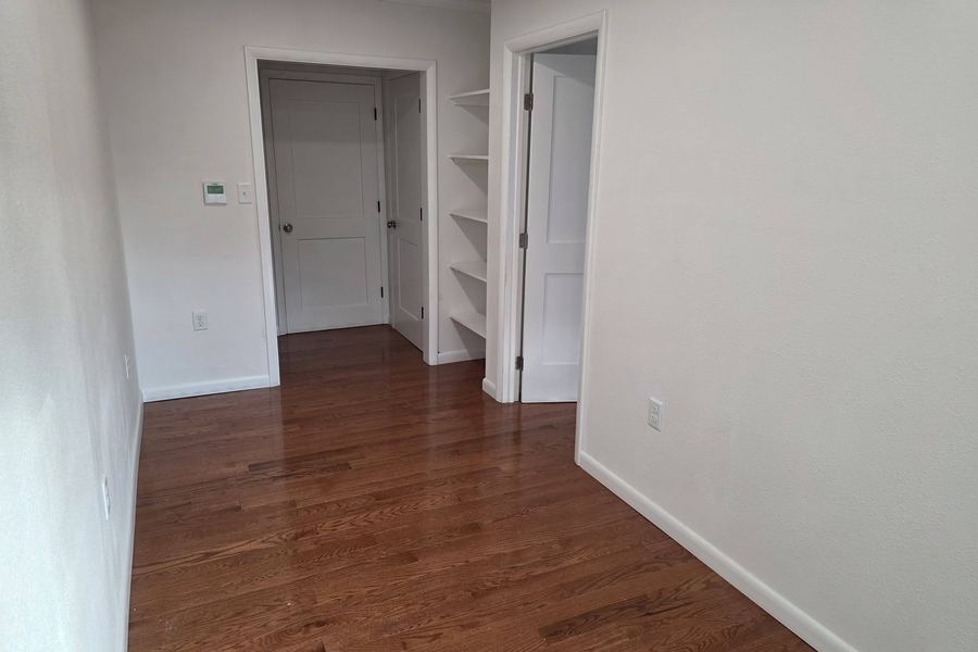 Hallway with new built-in shelving, five-panel doors, and refinished oak floors