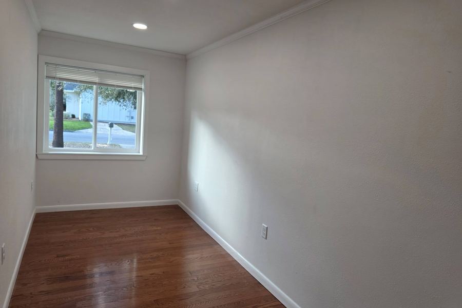Bedroom with new crown molding, window casing, and baseboard over oak floors