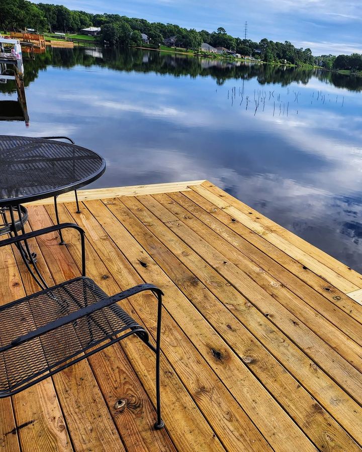 Corner of the dock platform with a small table, boards running clean to the edge trim