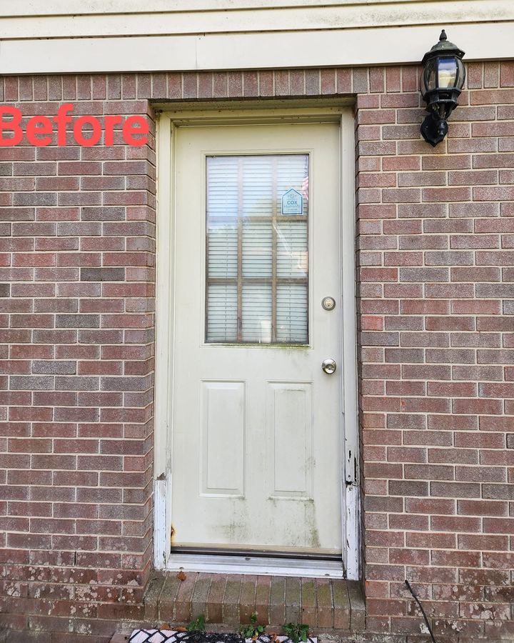 Worn entry door in a brick wall before replacement