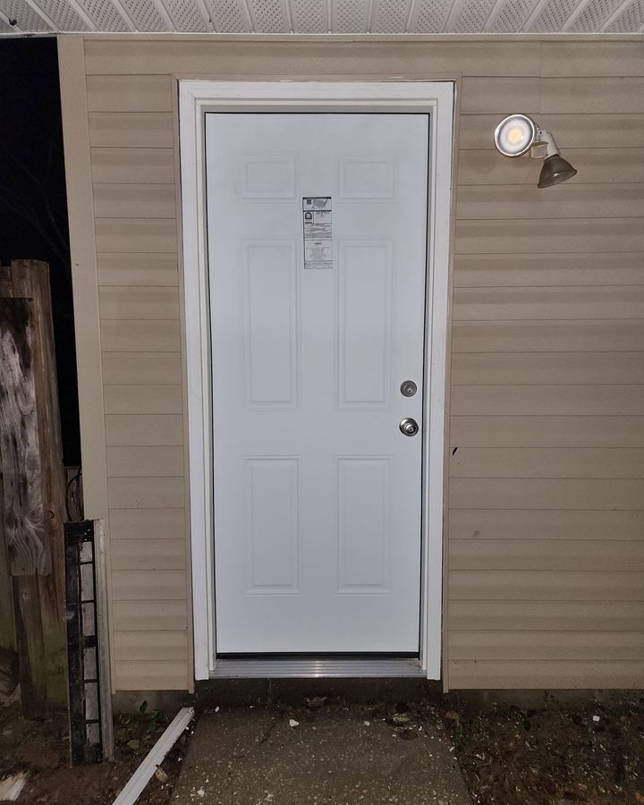 The same opening with a new prehung steel door, threshold, and trim
