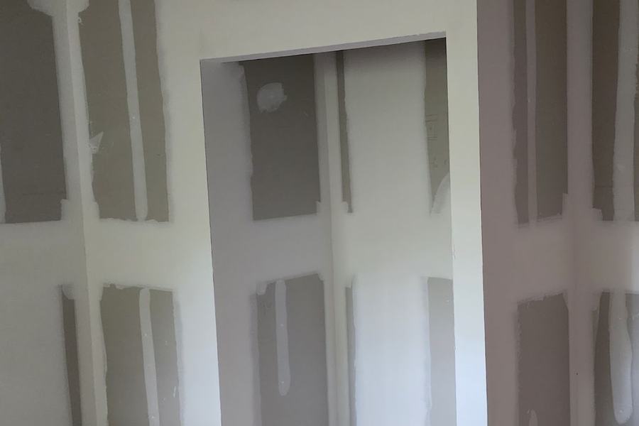Freshly hung and taped drywall around a closet opening, ready for finishing