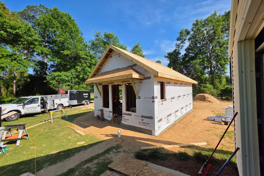 New build framed, sheathed, and wrapped, with the Hemken Construction trailer parked on site