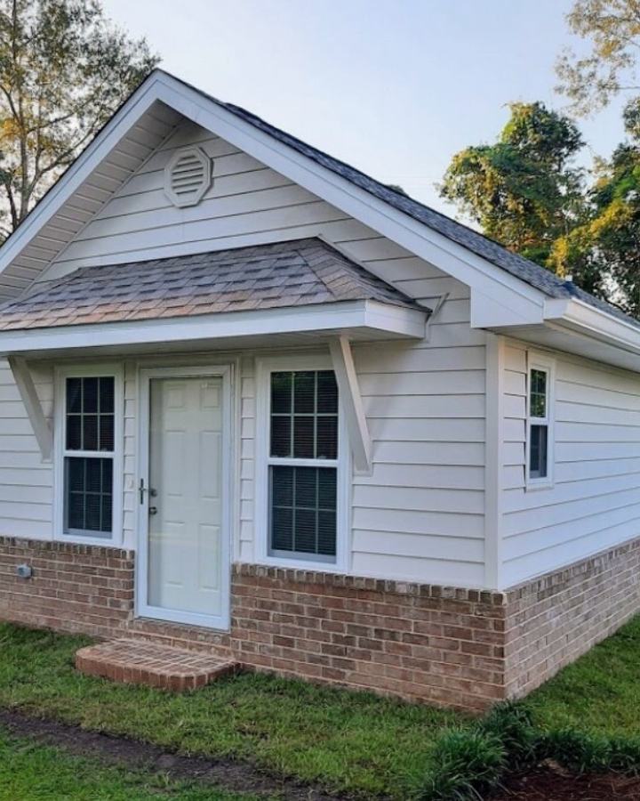 Front of the finished new build: six-over-six windows, entry door, and brick steps