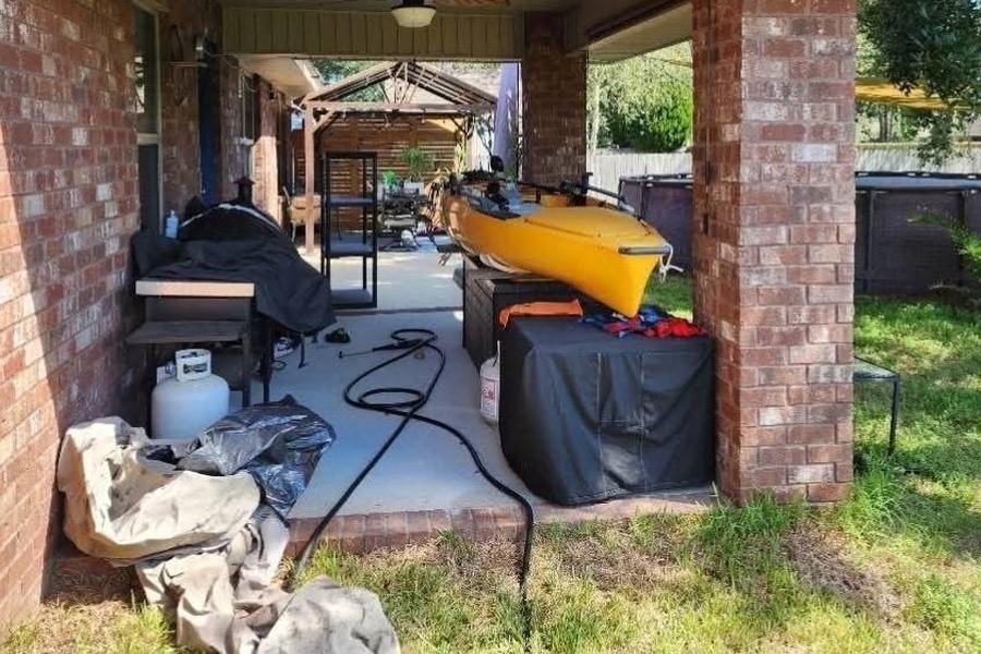 The same space before: an open brick patio used for storage