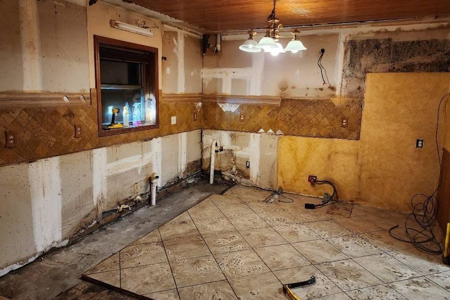 Kitchen gutted to the studs mid-remodel, with new framing and rough plumbing exposed