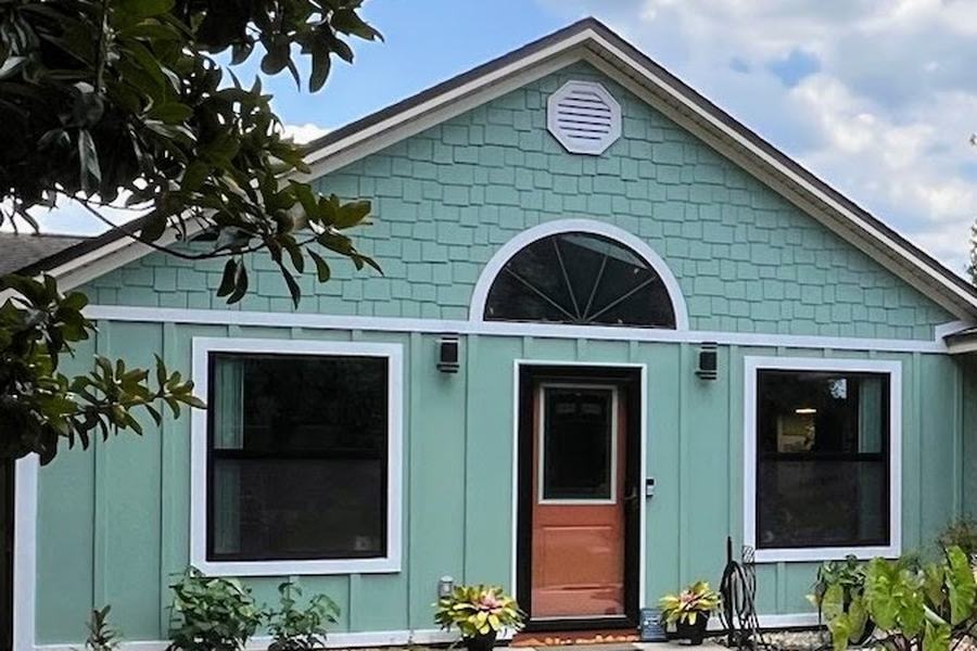 House front after new board-and-batten siding with a shake gable, painted seafoam with white trim
