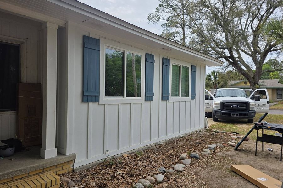 Side of the addition showing board-and-batten siding, shutters, and the new porch post